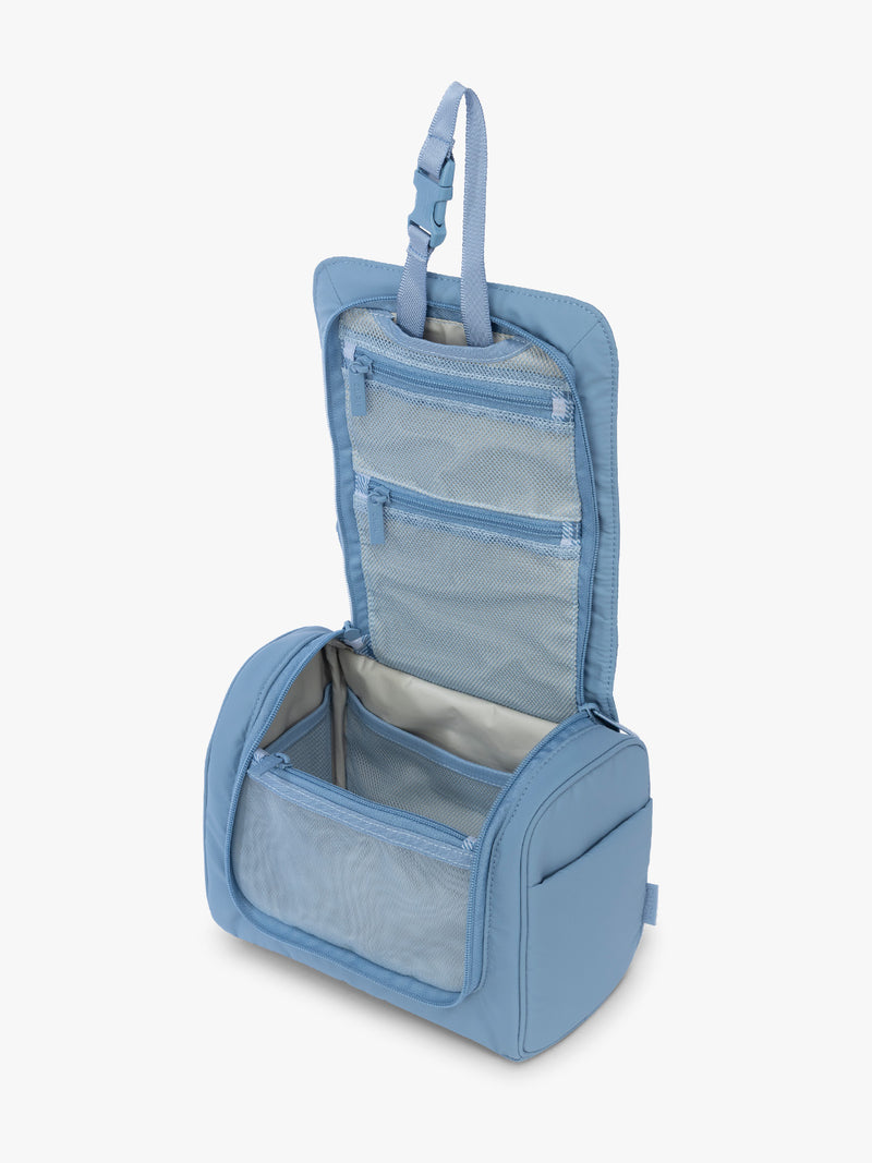 Opened view of the CALPAK Luka Hanging Toiletry Bag in light blue French Blue