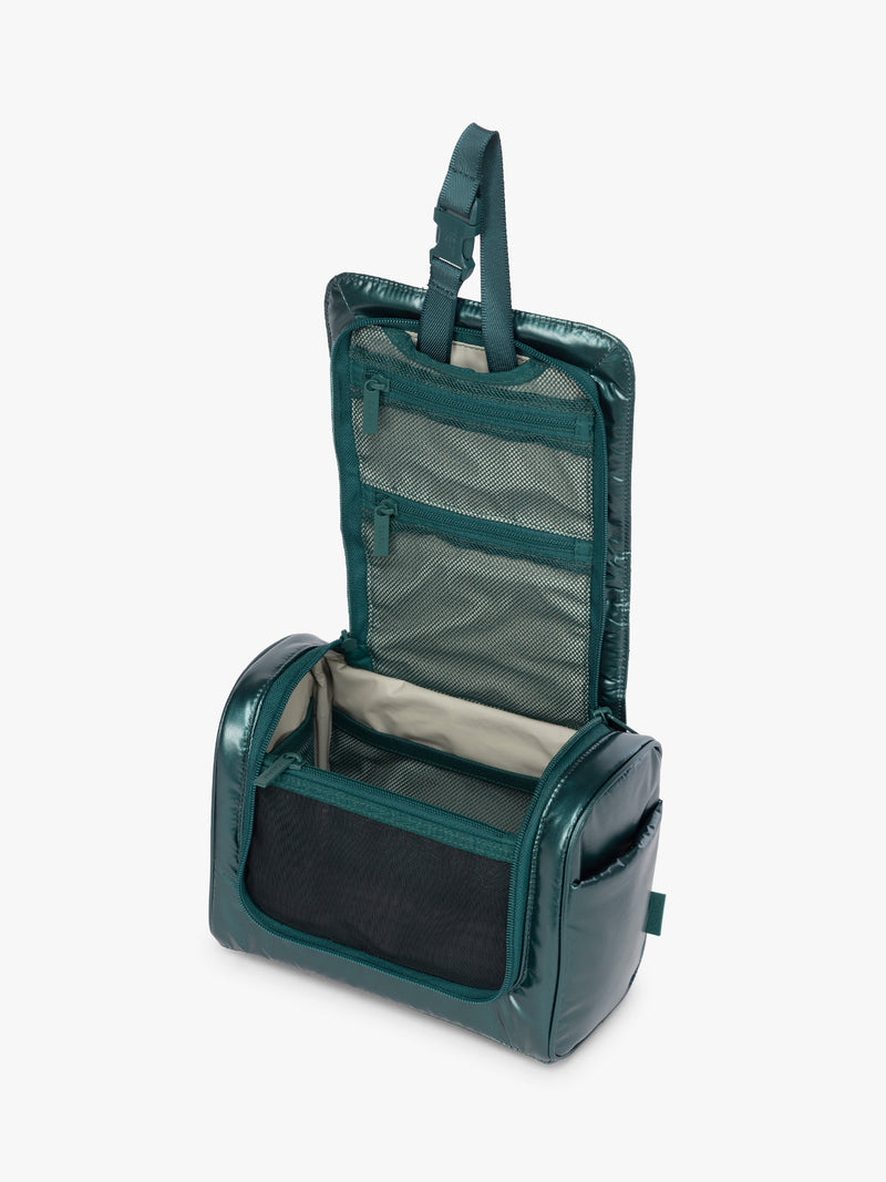 Opened CALPAK Luka Hanging Toiletry Bag in dark green shiny Kale