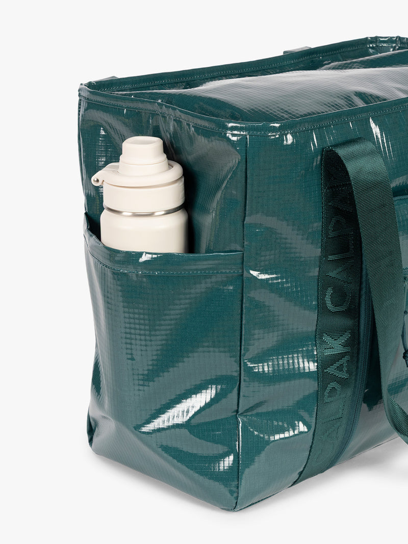 Side Water bottle holder of CALPAK Terra 35L Tote Bag with zippers in blue green Kale on a white background