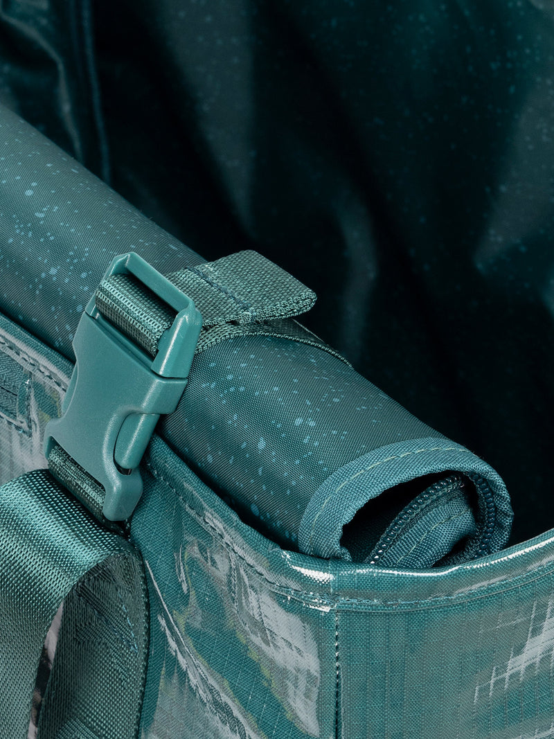 Rollable top of CALPAK Terra 35L Tote Bag with zippers in blue green Kale on a white background