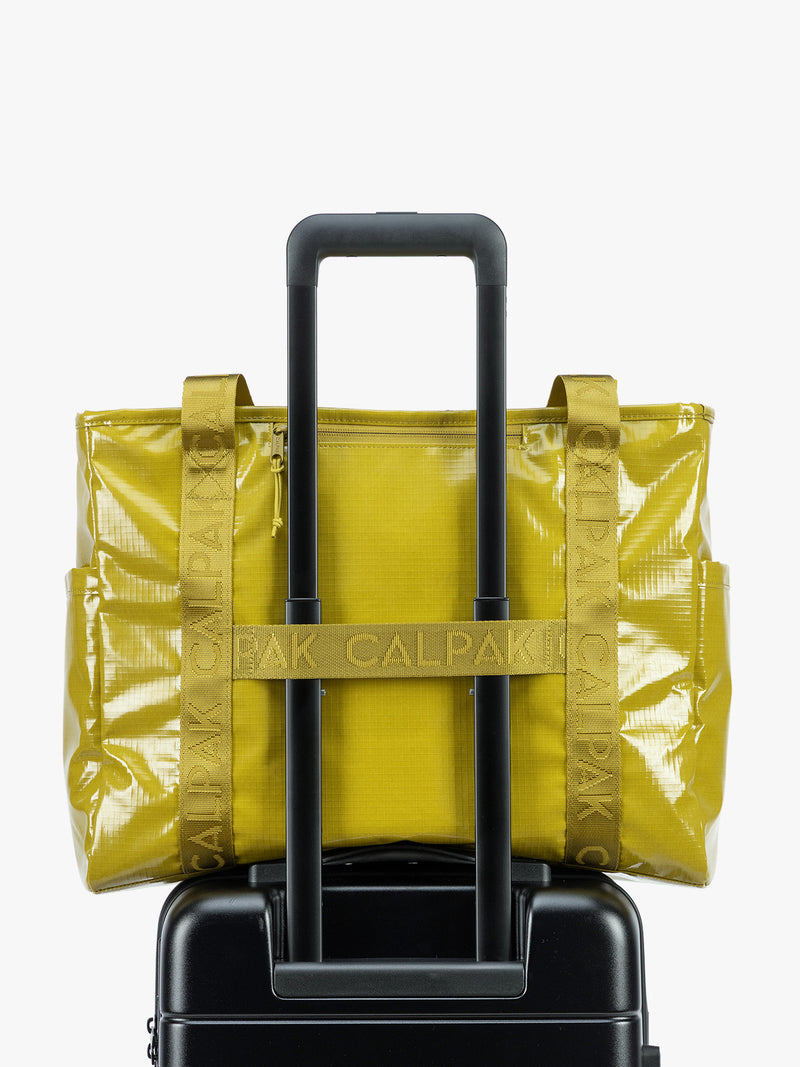 Back trolley sleeve of CALPAK Terra 35L Tote Bag with zippers in yellow green Wasabi on a white background