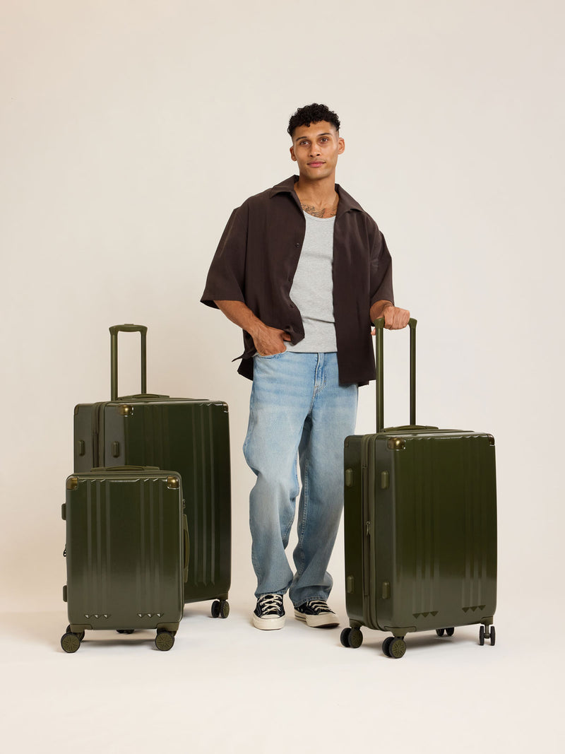 Model with CALPAK Ambeur 3pc dark green Pine Luggage Set