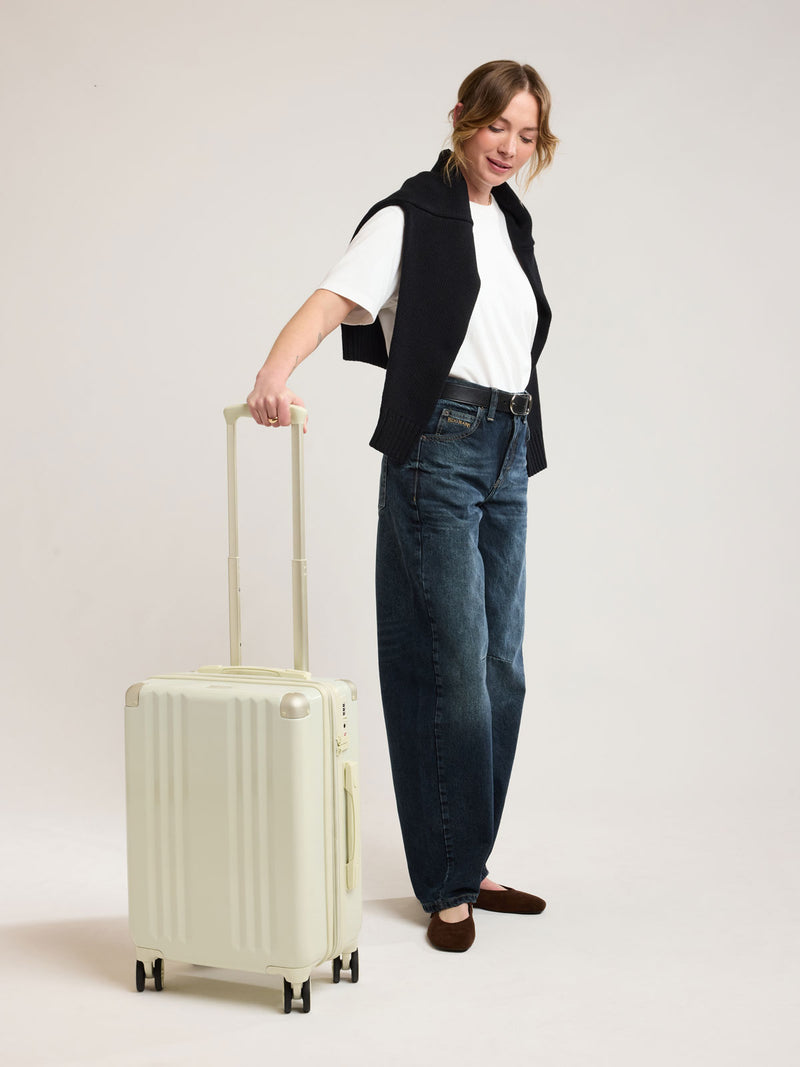 Woman with CALPAK Ambeur Carry on Luggage in light green Celadon