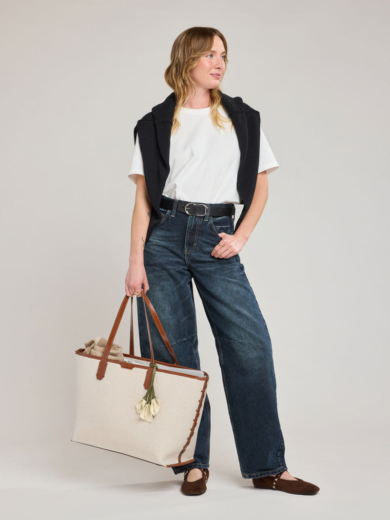 Model with CALPAK Colette 15" Canvas Laptop Tote in beige canvas material  with brown finishing in Natural Brown
