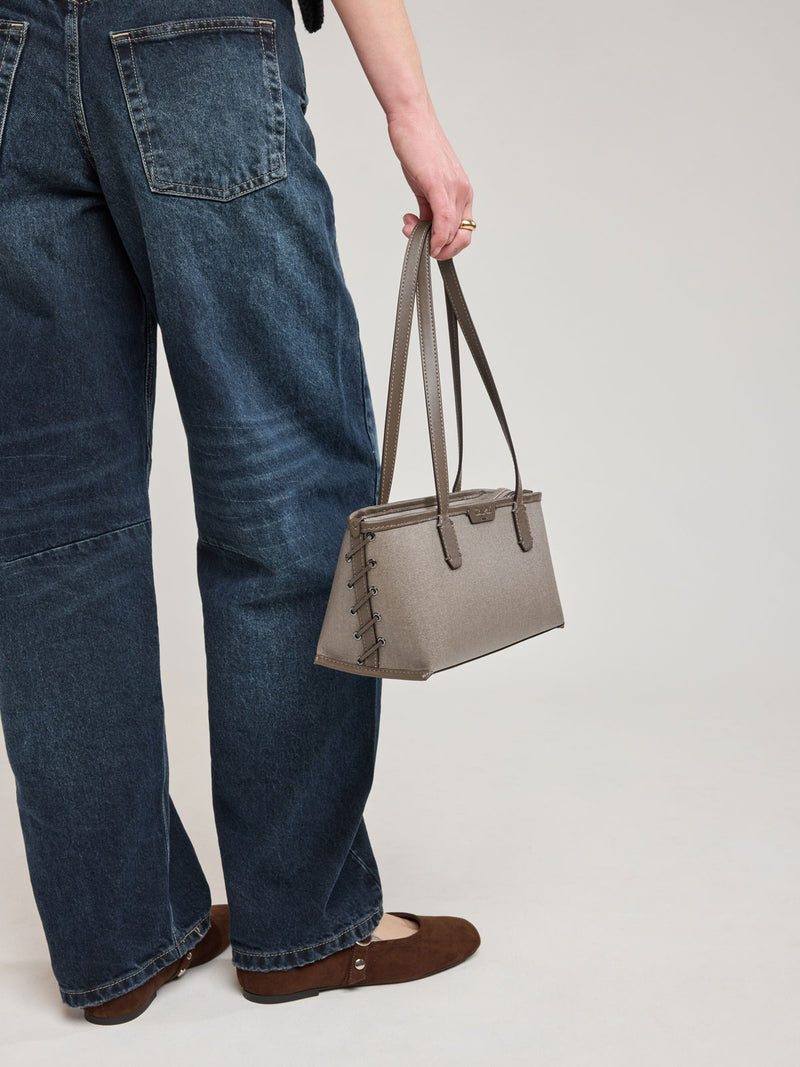 Woman holding CALPAK Colette Canvas Shoulder Tote in brown Mushroom canvas material