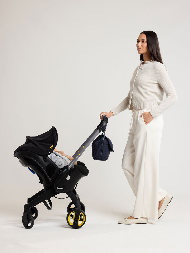 Woman with CALPAK Convertible Stroller Cady in blue Navy on a stroller