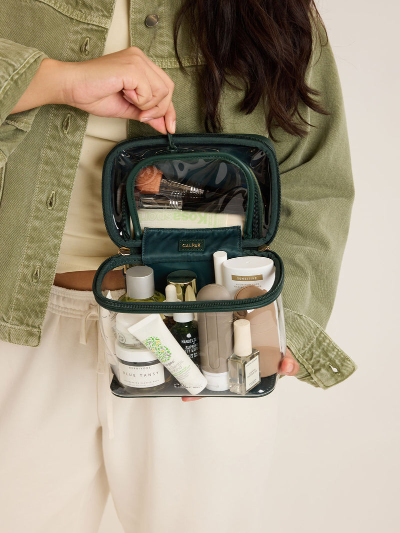 Model with the CALPAK Clear Train Case in dark green Emerald