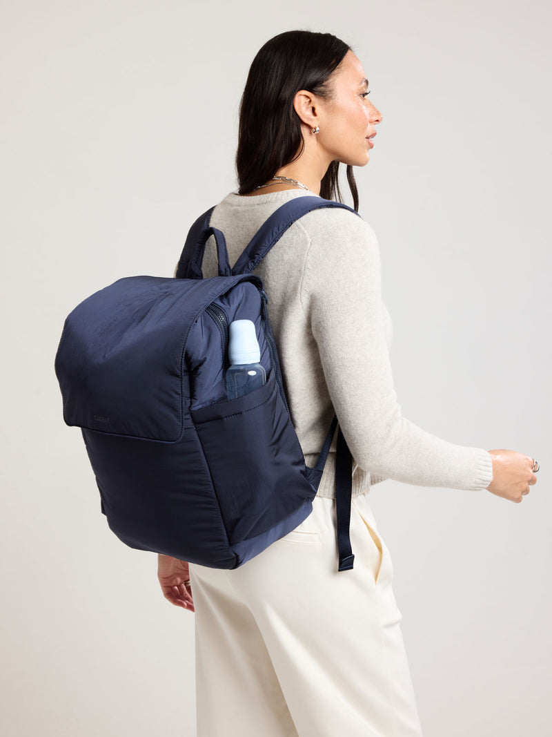 Woman wearing CALPAK Diaper Backpack in blue Navy