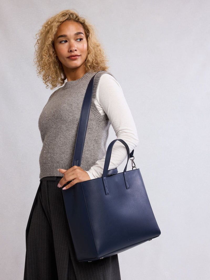 Woman wearing CALPAK Haven 15" Laptop Tote in dark blue Navy