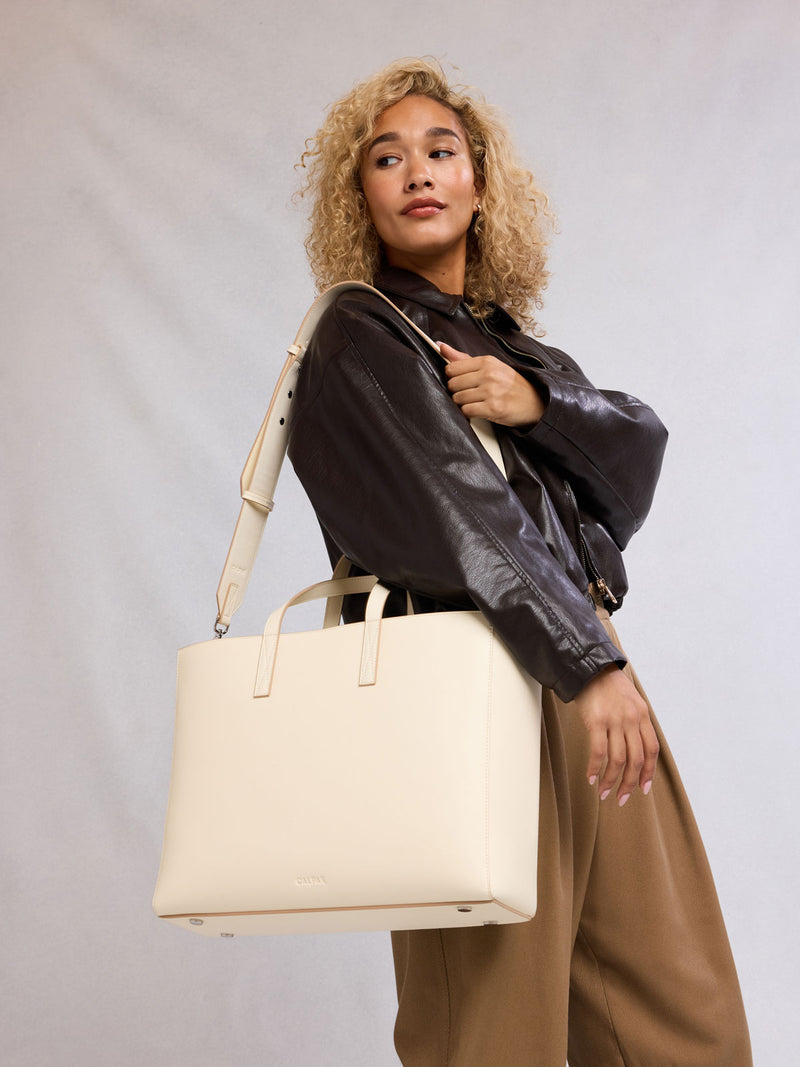 Model with CALPAK Haven 16" Laptop Tote in beige Buttercream