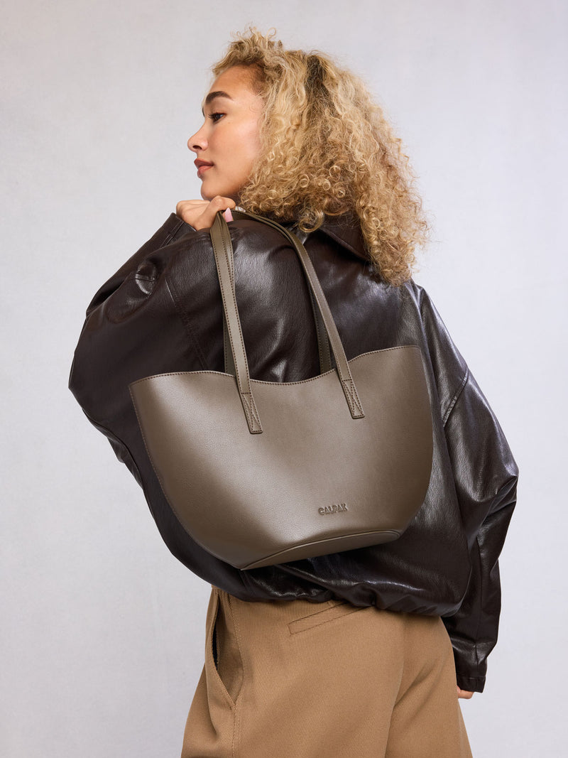 Woman with CALPAK Haven Tulip Tote in brown Mushroom