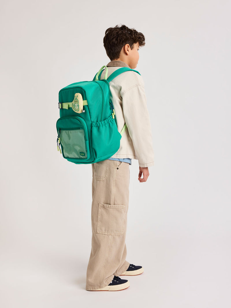 Child wearing Green CALPAK Kids Large Backpack with lime green accents on a white background
