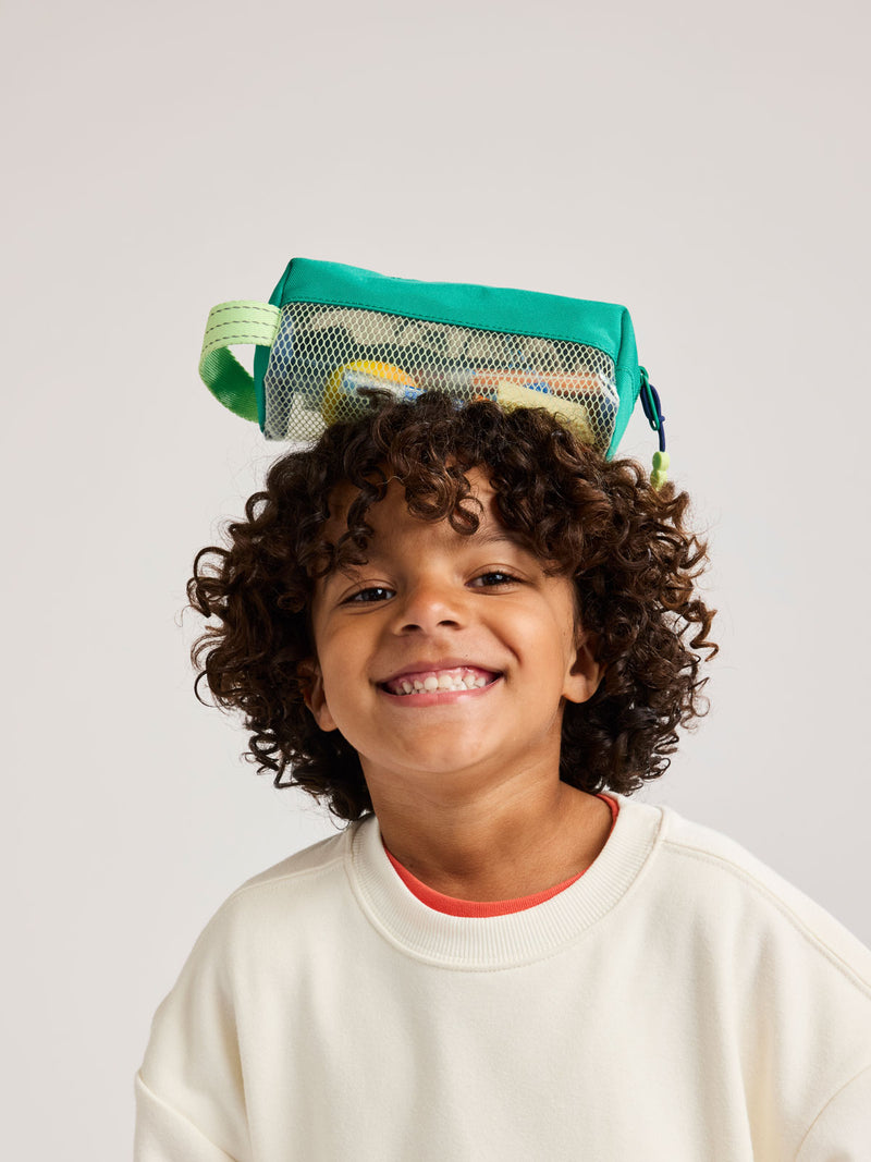 Child with Green CALPAK Kids Pencil Case with lime green accents and mesh bottom on a white background