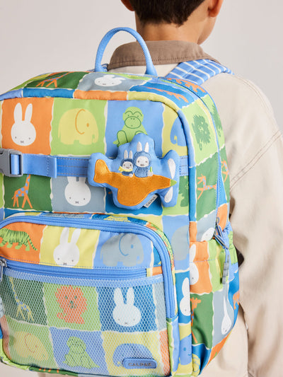 Plush Miffy x CALPAK Pluffy Bag Charm keychain with a blue border and Miffys holding a carrot on an orange airplane with a white background;APLF2501-MIFFY-ON-THE-WAY view 2