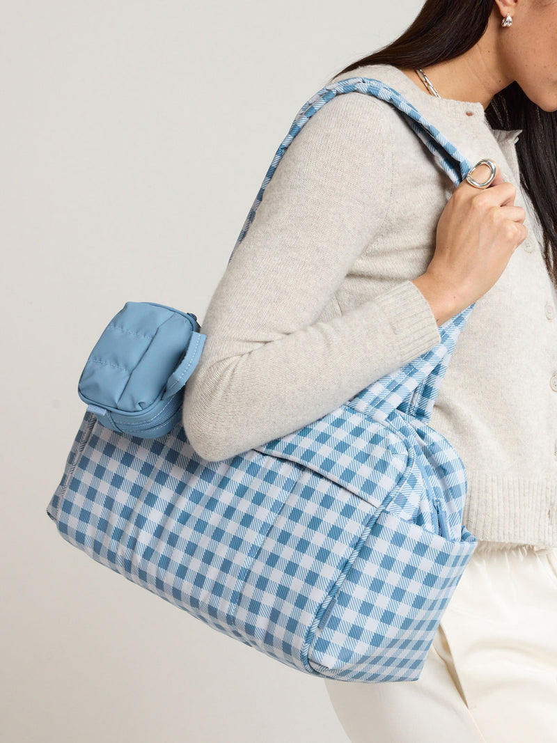Model with the CALPAK Luka Duffel Zip Bag Charm in light blue French Blue