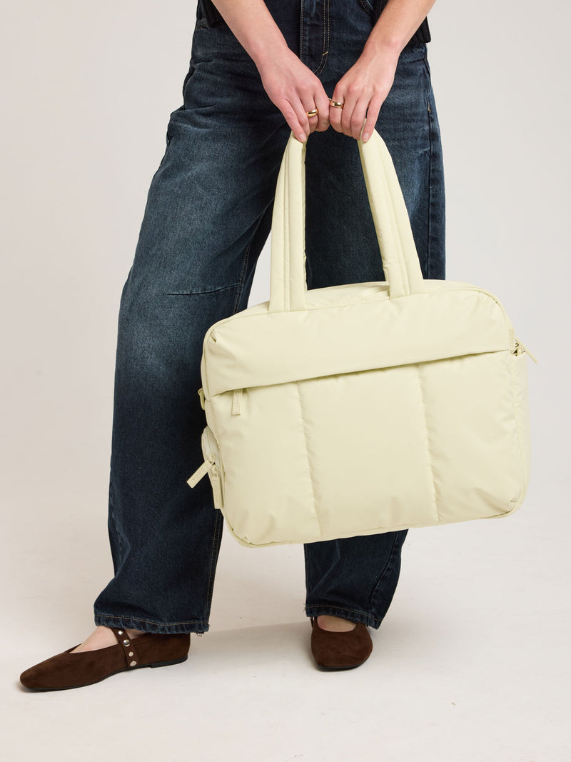 Person with CALPAK Luka Duffel in light green Celadon