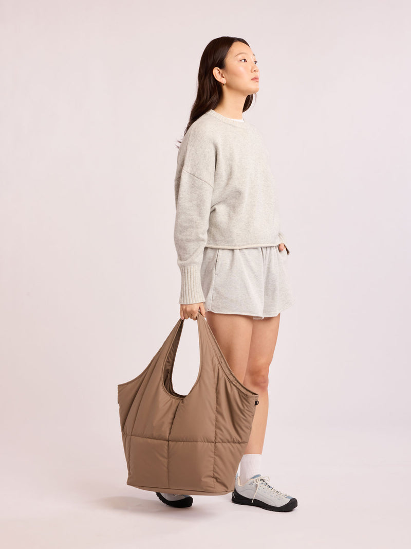 Model carrying CALPAK Luka Everything Tote in brown Chocolate