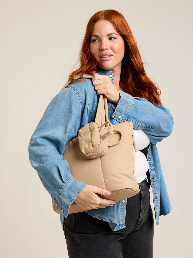 Model with CALPAK Luka Mini Tote in beige Latte on a white background
