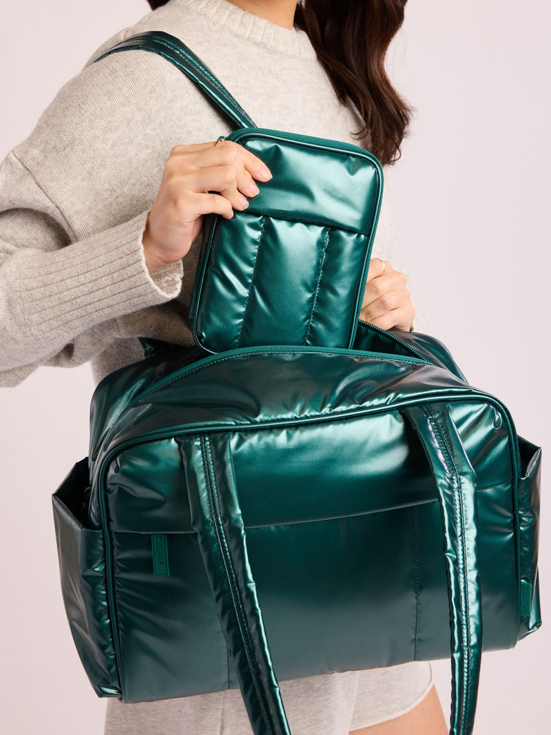 Woman with CALPAK Luka Zip Passport Wallet in dark green shiny Glazed Kale