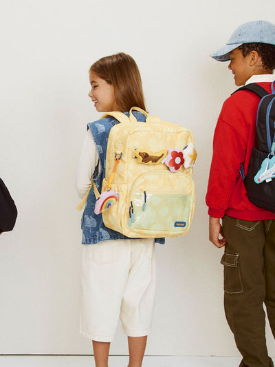 CALPAK Kids Medium Backpack in yellow with tan flower print in Yellow Bloom for ages 5-8 is built for your little one’s big days with yellow zippers and blue mesh front pocket, multiple interior pockets, and padded comfort straps; CKBM2501-YELLOW-BLOOM view 2