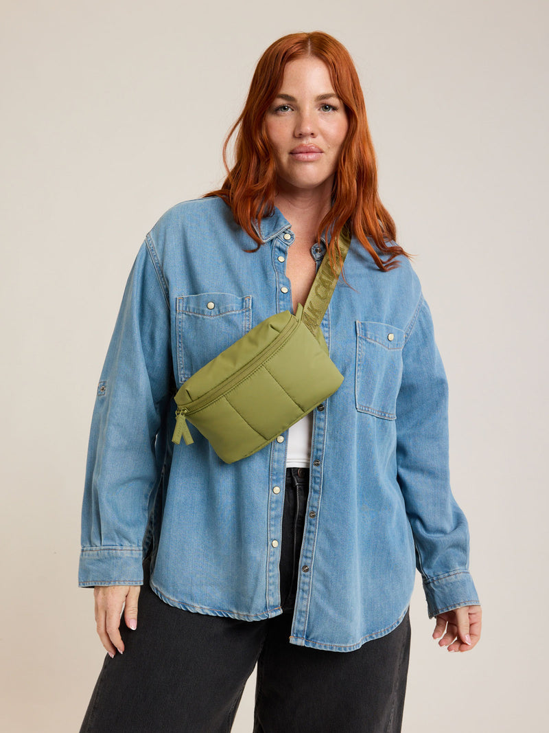 Model wearing CALPAK Luka Mini Belt Bag in dark green Pistachio on white background
