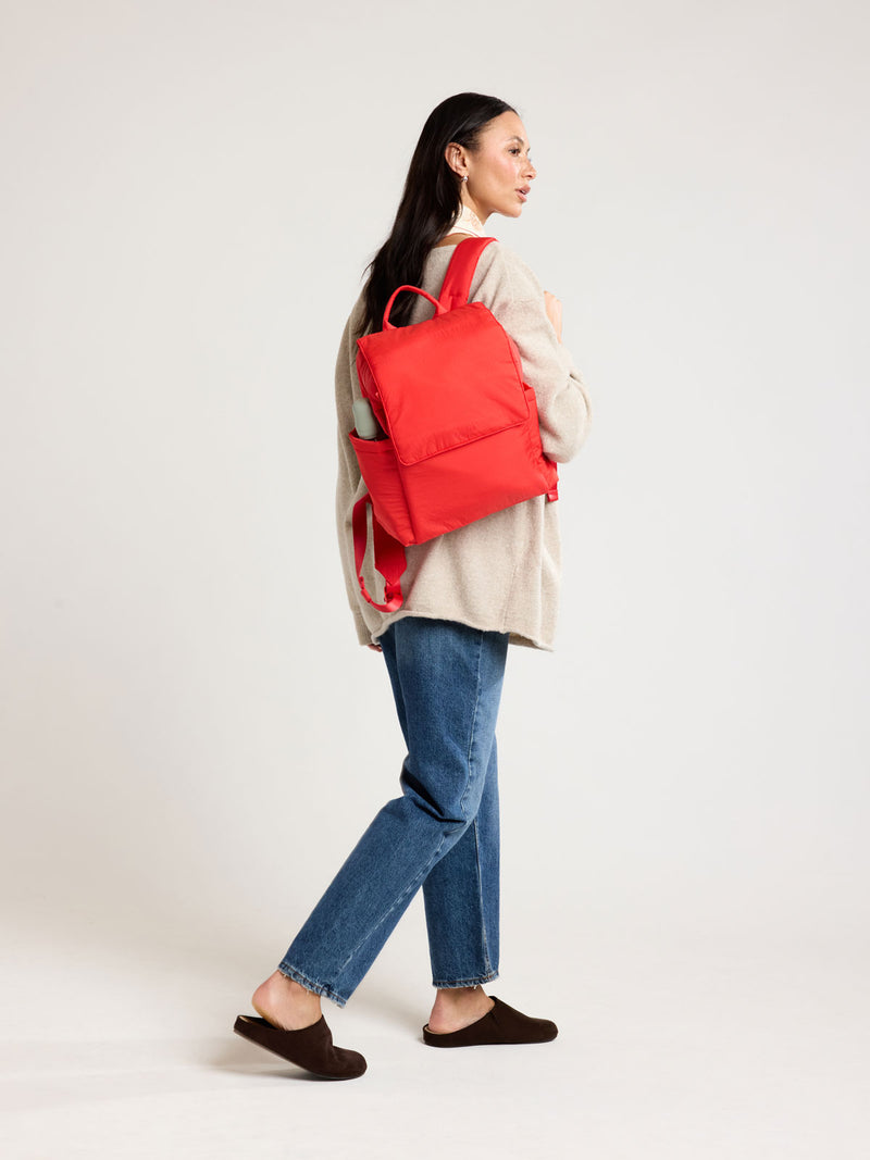 Woman wearing CALPAK Mini Diaper Backpack in red Tomato