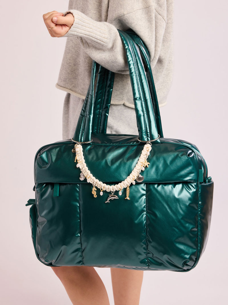 Woman with bag that has CALPAK Rope Bag Charm with white rope and sea shell charms