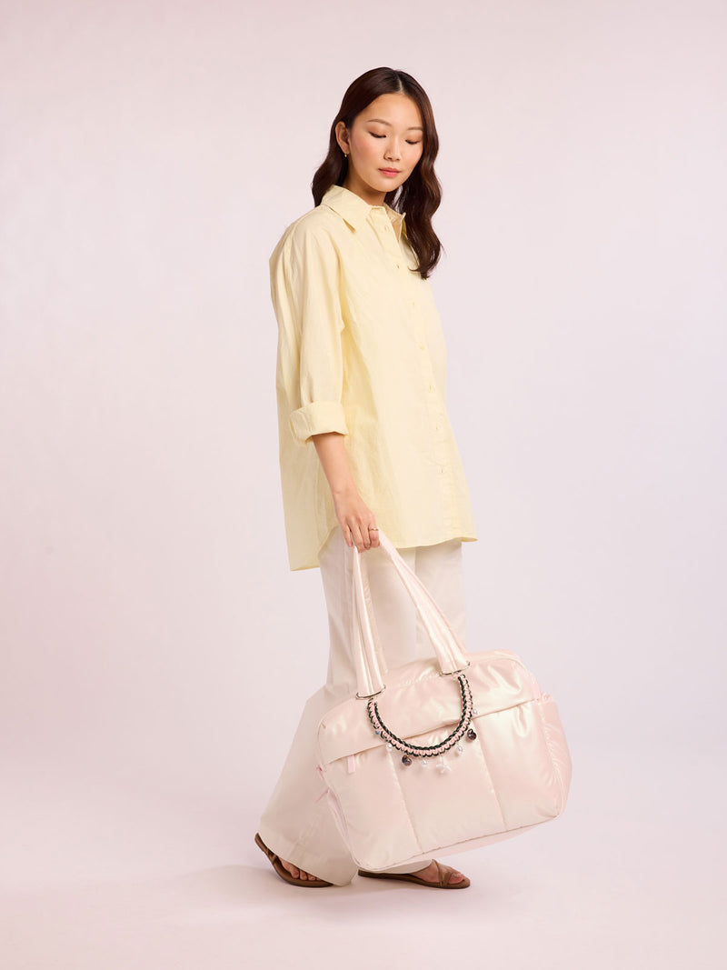 Woman with bag that has CALPAK Rope Bag charm in green and pink rope with sea life charms