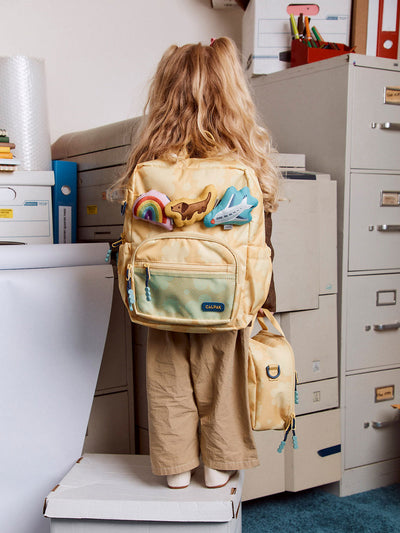CALPAK Kids Small Backpack in yellow with tan flower print in Yellow Bloom for ages 3-5 is built for your little one’s big days with yellow zippers and blue mesh front pocket, multiple interior pockets for an 11” tablet or laptop, and padded comfort straps; CKBS2501-YELLOW-BLOOM view 2