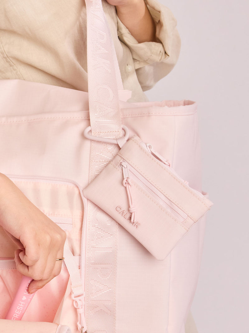 CALPAK Terra Clippable Card Pouch in shiny pink Shell Pink on a white background with a carabiner clipped on bag