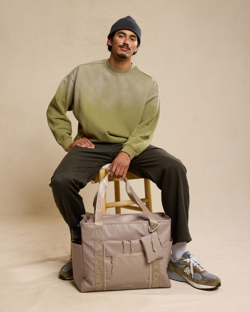 Model with CALPAK Terra 35L Tote in beige Stone front