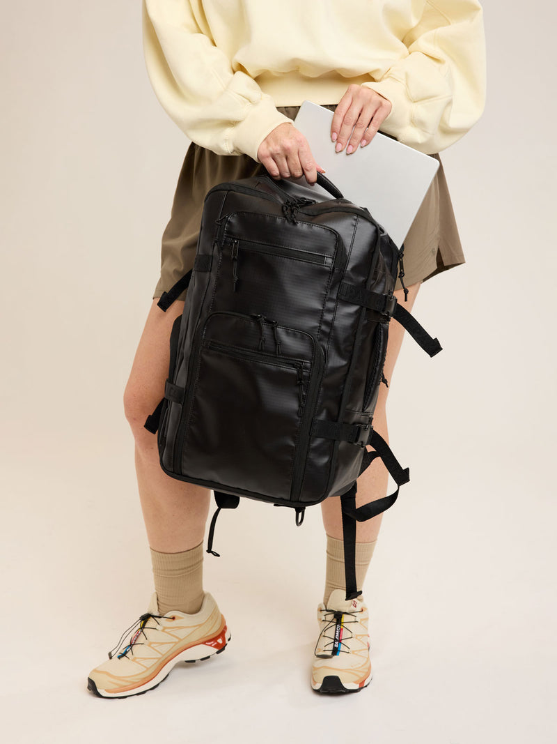Model with CALPAK Terra 26L Laptop Duffel Backpack in black Matte Obsidian front view