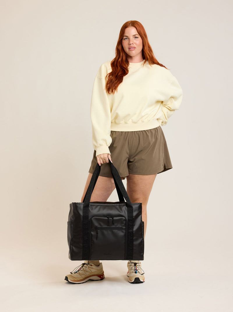 Model with CALPAK Terra 35L Tote in black Matte Obsidian
