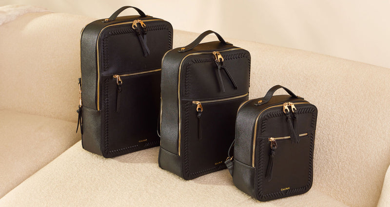 CALPAK Kaya Collection Kaya Backpacks shown in size order of 17", 15" and mini all in black with gold zipper